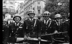 Sur cette photographie de Gilles Caron, des CRS empruntent la rue des Ecoles aux abords de la Sorbonne pendant la manifestation du 6 mai 1968 à  Paris.  Photo : Fondation Gilles CARON / GAMMA-RAPHO
