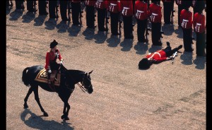 Un garde royal perd connaissance alors que la reine Elizabeth II passe à ses côtés lors d’une parade militaire, en juin 1970 à Londres.  Photo : GAMMA